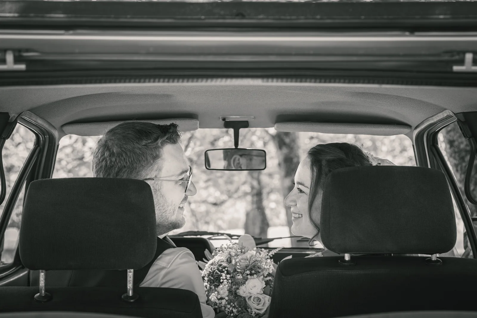 Brautpaar im Hochzeitsauto durch den Kofferraum fotografiert