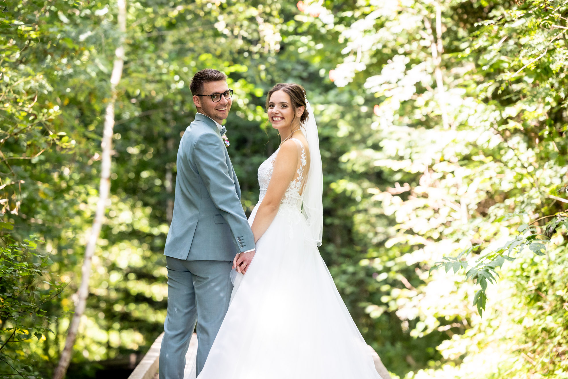 Hochzeitspaar auf Steg in Wald